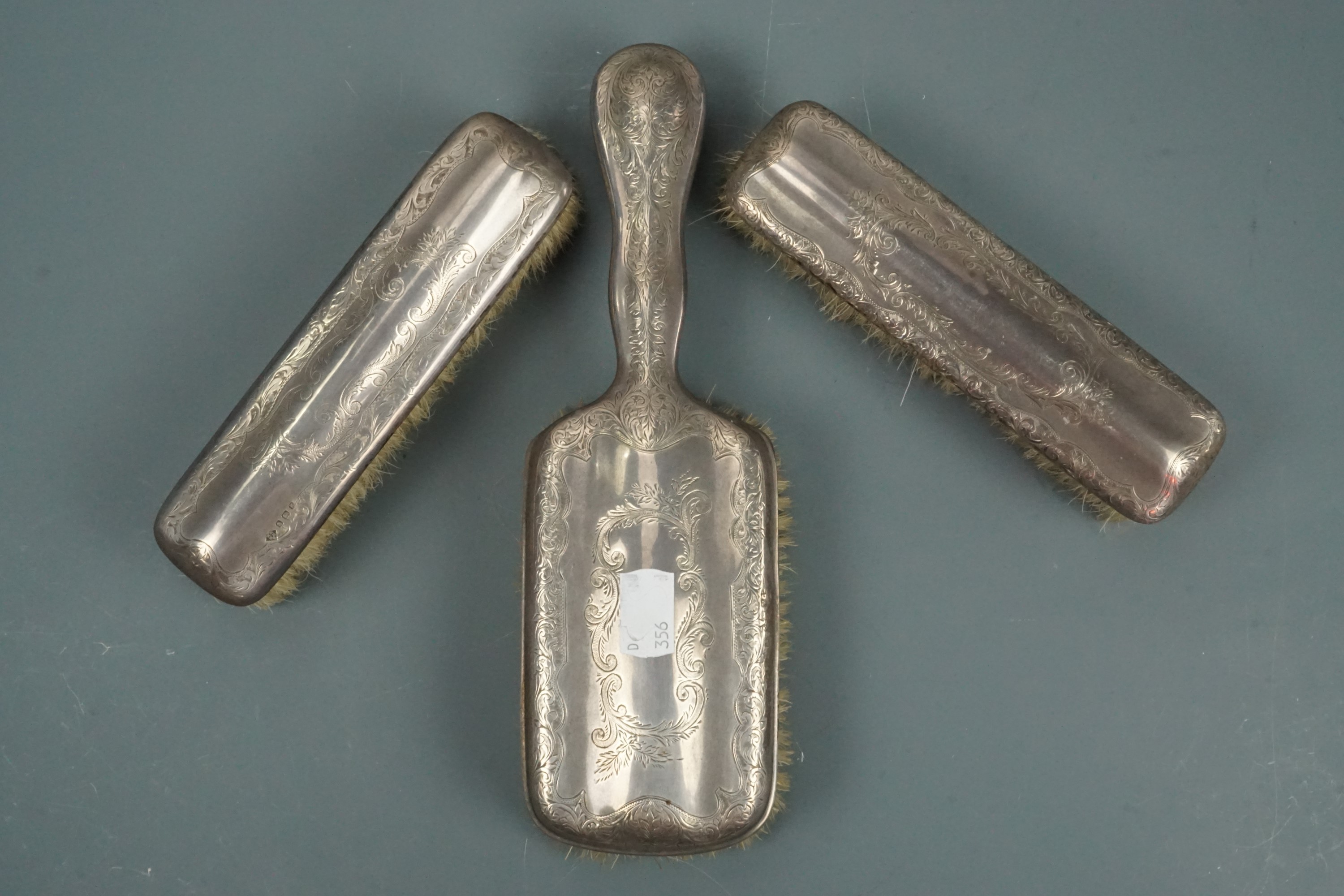 An Edwardian silver-backed three-piece brush set
