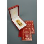 A 1990s lady's Must de Cartier gold plated cigarette lighter, a gift from Eric Clapton to a member