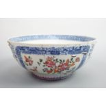 An 18th Century Chinese export bowl, decorated with flowers and insects reserved within blue