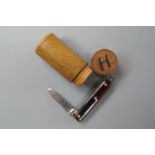 A 19th Century small treen cylindrical screw-capped box containing a miniature pocket folding knife,