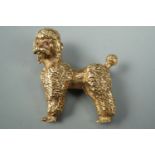 A yellow metal brooch modelled as a poodle, having ruby eyes, stamped 14K, 3 cm x 3 cm, 9.3 g
