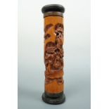 A Japanese bamboo carving, depicting figures playing a board game within in a garden scene,