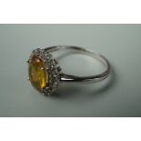 A contemporary 9ct white gold dress ring, having a central yellow paste stone, size T 1/2, 2.5g