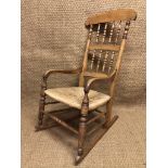 A Victorian rush-seated spindle-back beech rocking armchair