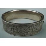 A 1950s engraved silver hinged bangle, 6 cm x 5.5 cm internally