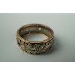 A two-colour yellow metal wedding band, fretted and engraved in a scroll and blossom pattern, O,