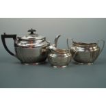 An Edwardian silver three-piece tea set, each element of Georgian influenced shouldered form with