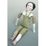 A 19th Century German import china head and shoulder doll, on a green checked cloth body with glazed