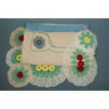 A vintage embroidered tablecloth together with a set of crocheted flowerhead pattern table mats