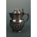 A late Victorian silver hot water jug, loosely of 17th Century form, having a domed lid and