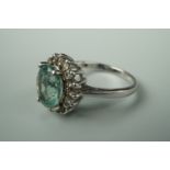 A contemporary green stone dress ring, in a flower head cluster setting, stamped 935 and tested as