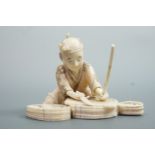 A Meiji Japanese marine ivory okimono depicting a fisherman squatting about to prepare his catch,