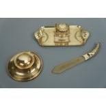 Two early 20th Century brass ink wells and a brass-mounted horn paper knife