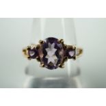 A contemporary three-stone amethyst dress ring, on 9ct gold, size N 1/2, with certificate of
