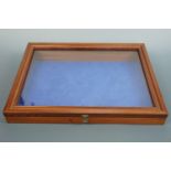 A contemporary glazed table-top display cabinet with canted hinged top, 60 x 45 x 11-7 cm