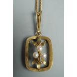 A yellow metal and pearl modernist openwork pendant in the form of three berries and leaves within a