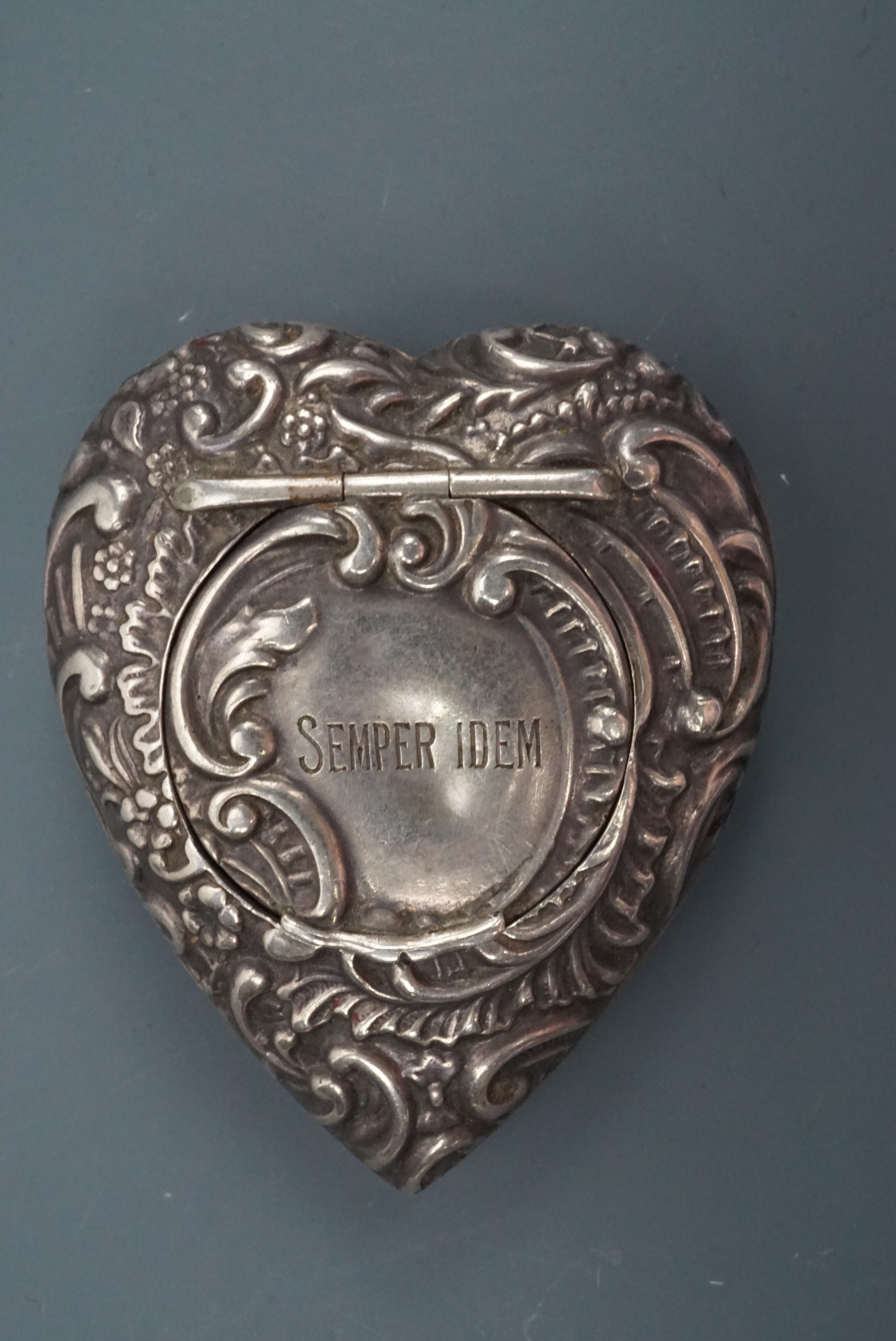 A late Victorian silver heart-shaped patch or similar box, each face relief-decorated in a rococo