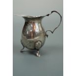 An Edwardian silver cream jug, oviform with compound scroll handle and three anthemion-hipped