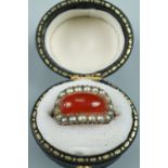 A Georgian carnelian and pearl finger ring, comprising a contoured rounded oblong carnelian cabochon