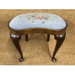 A 1930s walnut dressing table stool having slender cabriole legs