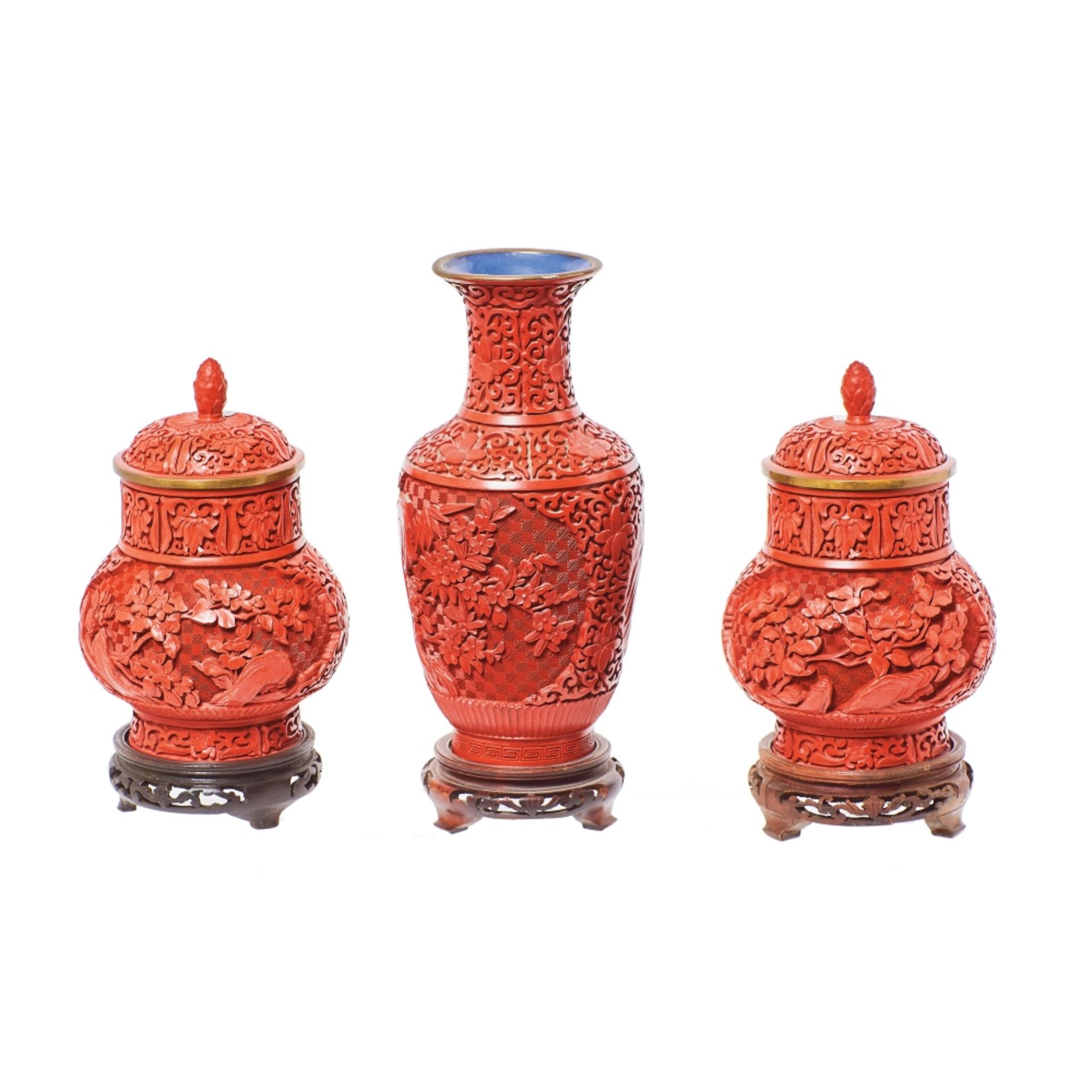 Lote de jarrón y pareja de tibores chinos en laca roja tallada.