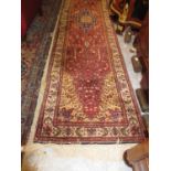 Indo Persian runner with a medallion and all-over stylised floral design on a red ground with