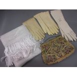 Three pairs of ladies gloves, needlework evening purse, scarf, two under skirts and a bed cover