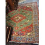 Afghan rug of Kurdish design with a single central medallion in shades of brick red, green and blue,