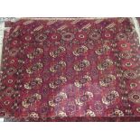 Tekke rug with four rows of nine gols on a wine red ground with borders, 5ft 10ins x 3ft 10ins