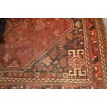 Shiraz carpet of medallion design on a red and black ground with borders, 6.5ft x 9.5ft