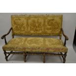 Late 19th / early 20th Century upholstered and walnut framed sofa with carved scroll arms raised