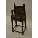 Child's oak high chair in 17th Century style with a carved panel back, panel seat and carved