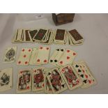 Boxed set of miniature playing cards decorated with a swastika motif together with a pair of