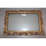 19th Century Italian carved giltwood picture frame having pierced C-scroll decoration, aperture size