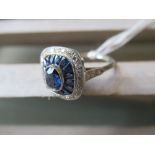 Platinum ring set centre oval sapphire surrounded by halo of calibre cut sapphires and diamonds