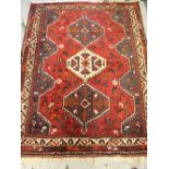 20th Century Shiraz rug with a pole medallion design on red ground, 5ft 6ins x 4ft 2ins