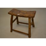 Antique elm stool with a curved seat raised on splay supports with stretchers This stool is sturdy