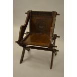 Late 19th Century oak Glastonbury type chair with carved panel back and arms, raised on crossover