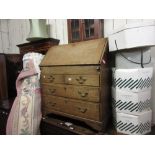 Oak bureau with a fall front above two short and two long drawers with brass swan neck handles and