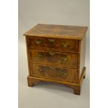 Small reproduction figured walnut and crossbanded three drawer chest raised on bracket feet