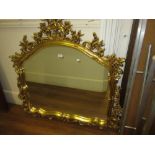 Ornate reproduction gilt framed overmantel mirror with a pierced floral surround, 46ins x 46ins