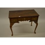 Walnut lowboy in 18th Century style, the crossbanded and moulded top above three drawers, shaped