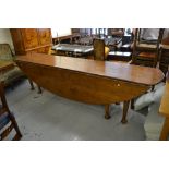 Large good quality reproduction oak hunt or wake table, the oval drop-leaf top raised on eight