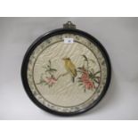 Chinese circular silk work picture of a bird in foliage in an ebonised frame, 16ins diameter,