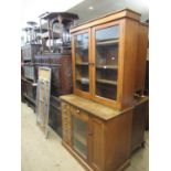 Early 20th Century oak estate cupboard with a pair of glazed doors, the base with an arrangement