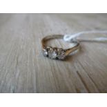 Small modern three stone diamond ring on an unmarked white metal shank