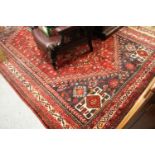 Shiraz carpet of centre medallion and all-over geometric design with borders on a wine ground,