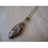 Boulder opal in a yellow metal pendant cage mount on chain