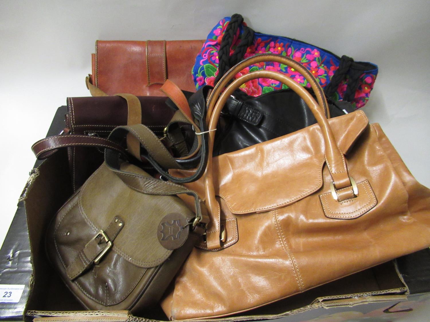 Box containing a collection of various ladies handbags including leather