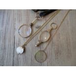 Two pairs of gilt metal mounted lorgnettes, one on 9ct gold chain, a monocle with holographic